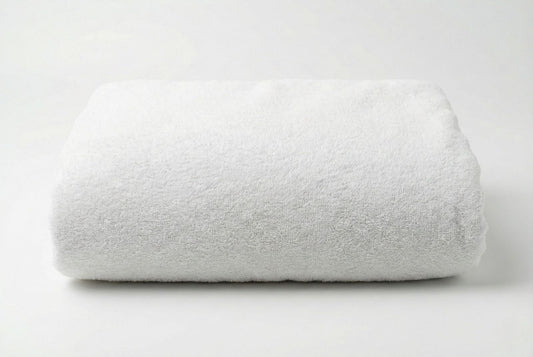 Folded big white Turkish cotton towel on a light gray background