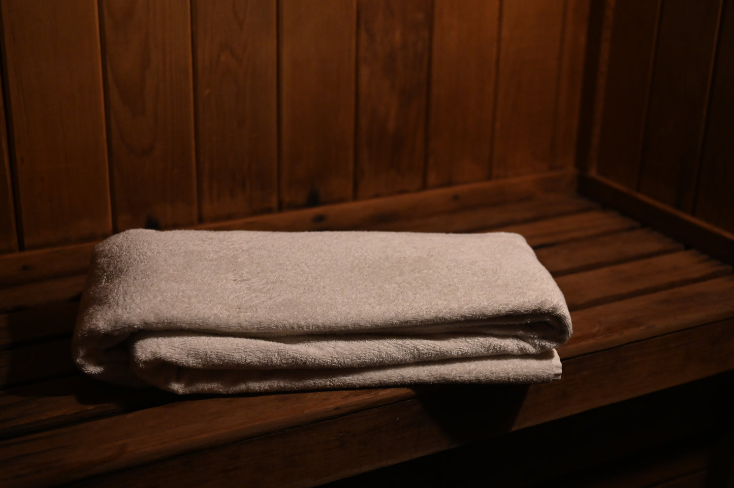Folded big towel on a wooden surface in a sauna